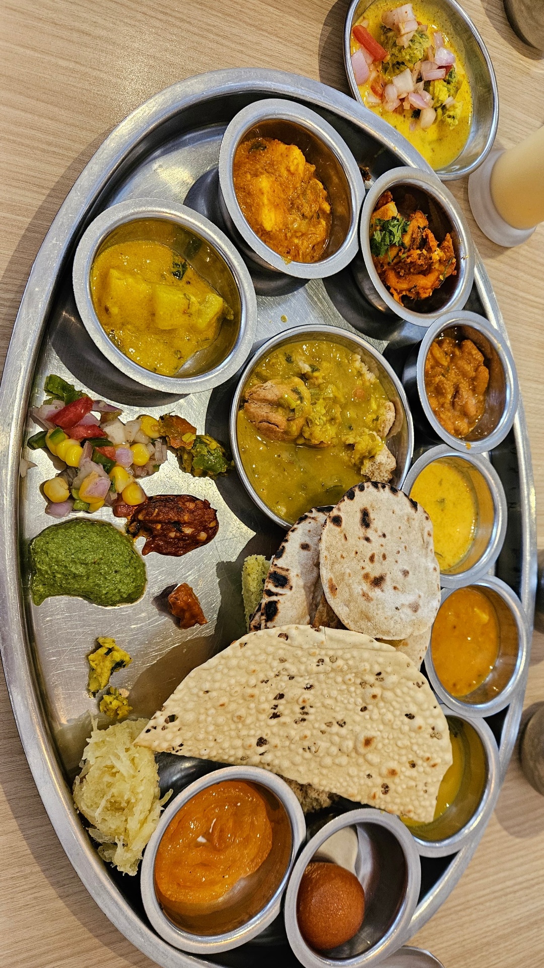 Traditional Indian thali with assorted curries, breads and chutneys