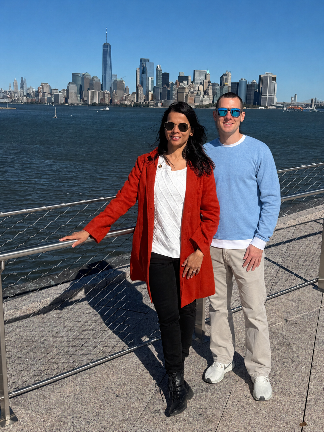 Your India trip planner with her partner, photographed on the New York harbor with the Manhattan skyline behind them